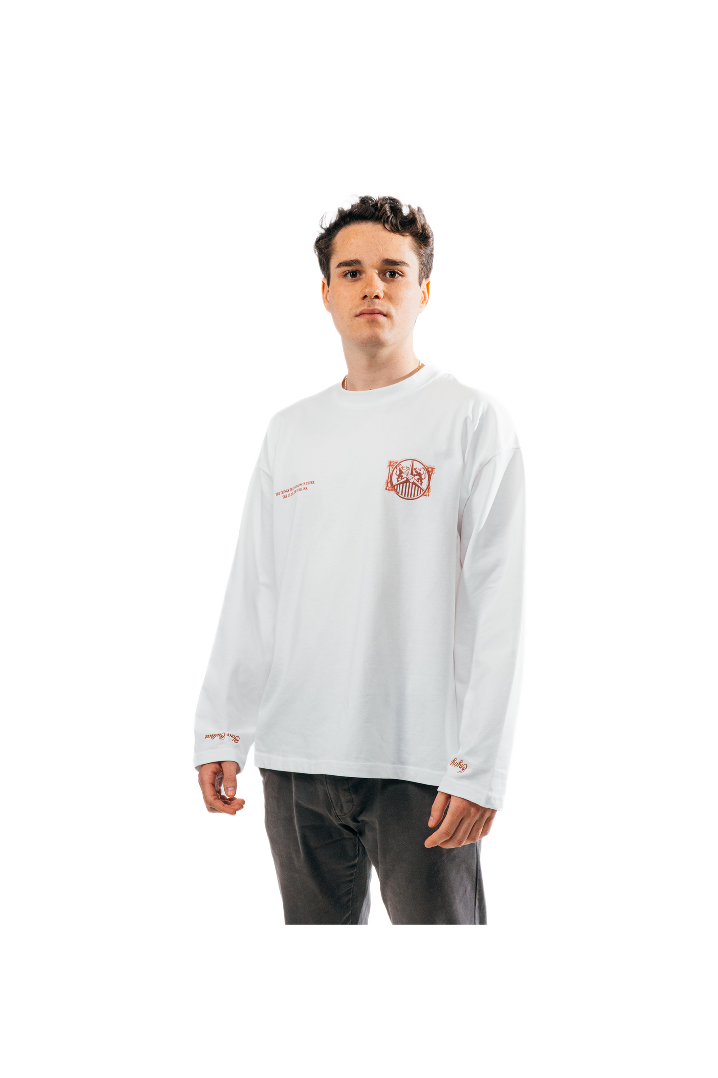 Modelo chico con camiseta manga larga Our Culture blanca de frente y pequeño escudo terracota en el pecho