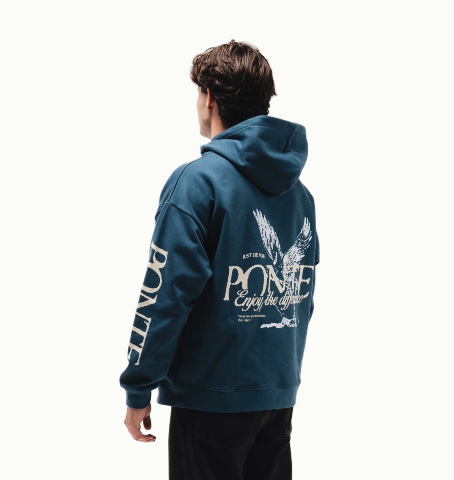 Modelo chico en tres cuartos con sudadera Fly Different Hoodie azul petróleo, águila blanca y PONTE