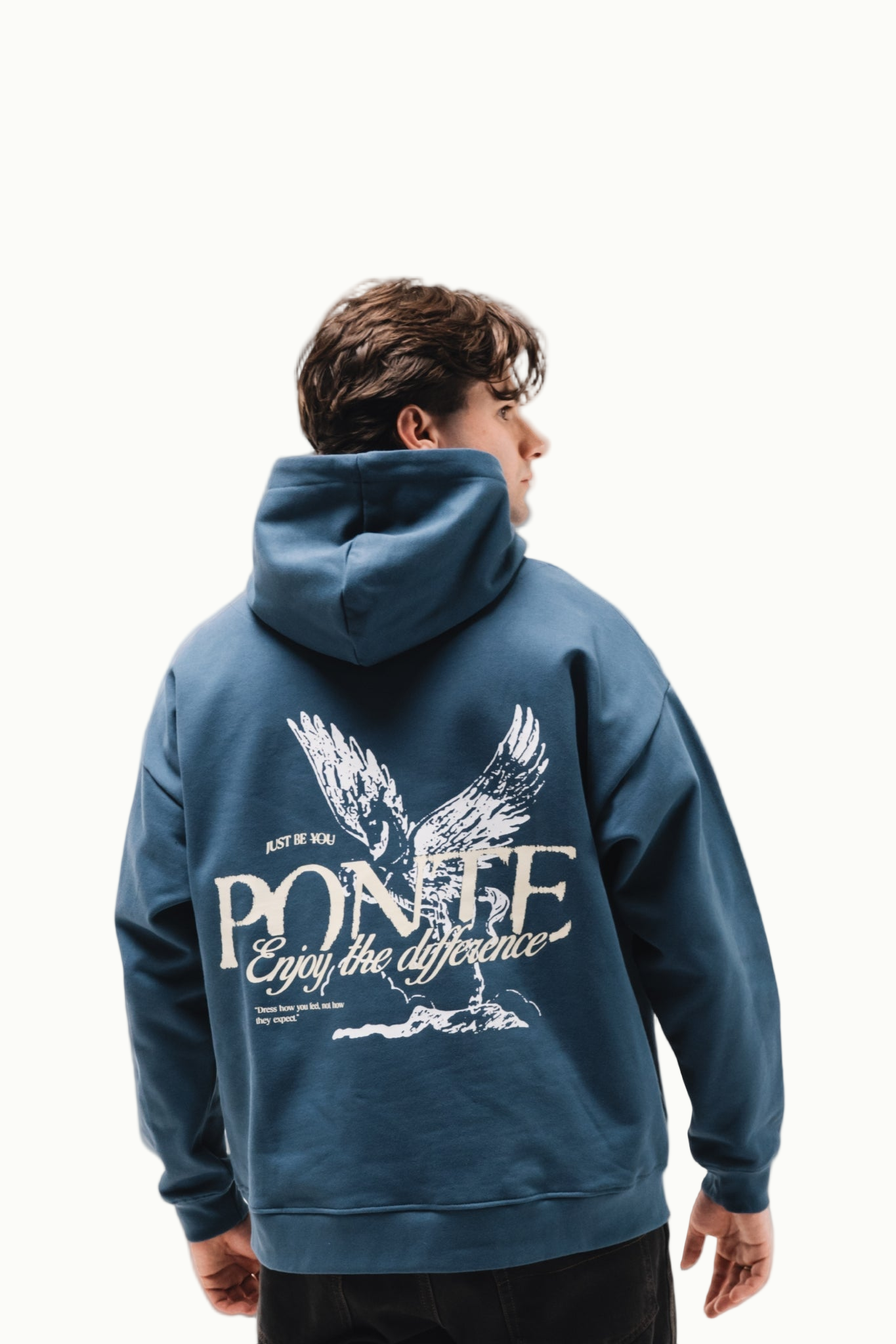 Modelo chico de espaldas con sudadera Fly Different Hoodie azul petróleo, águila blanca y letras PONTE