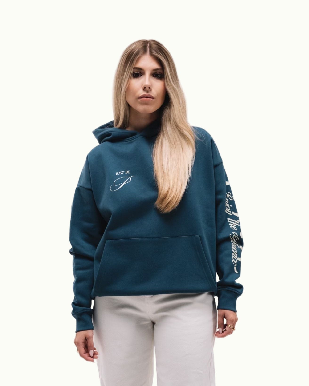 Modelo chica de frente con sudadera Fly Different Hoodie azul petróleo con letras crema en pecho