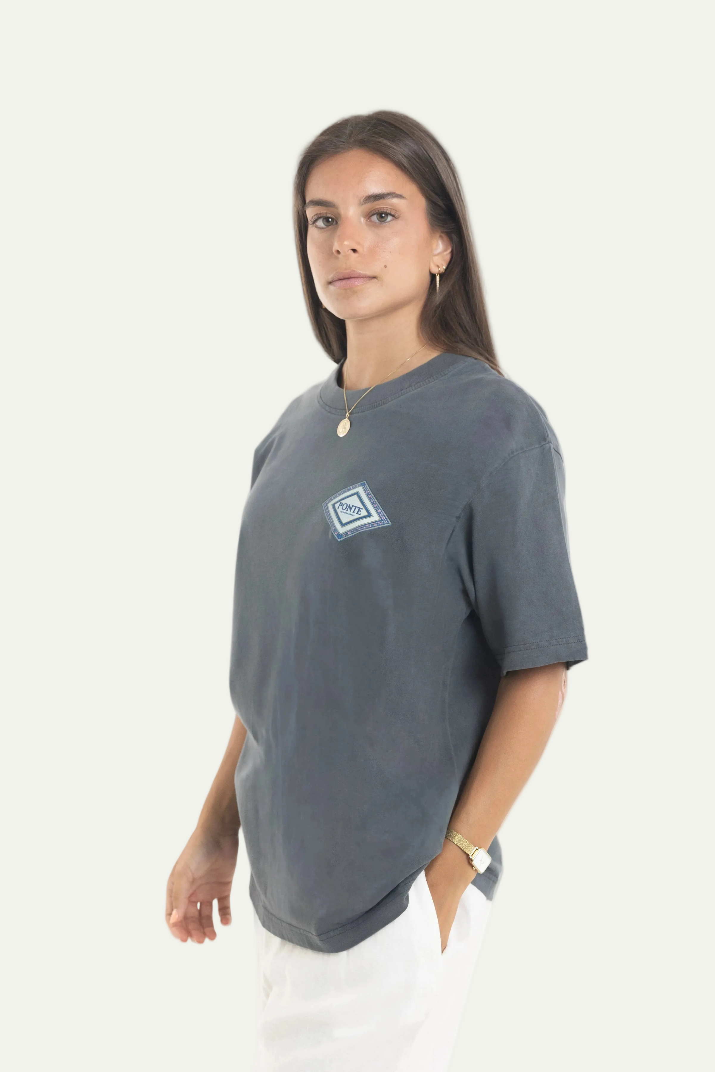 Chica de perfil con la camiseta The Med gris carbón, detalle del logotipo diamante PONTE.